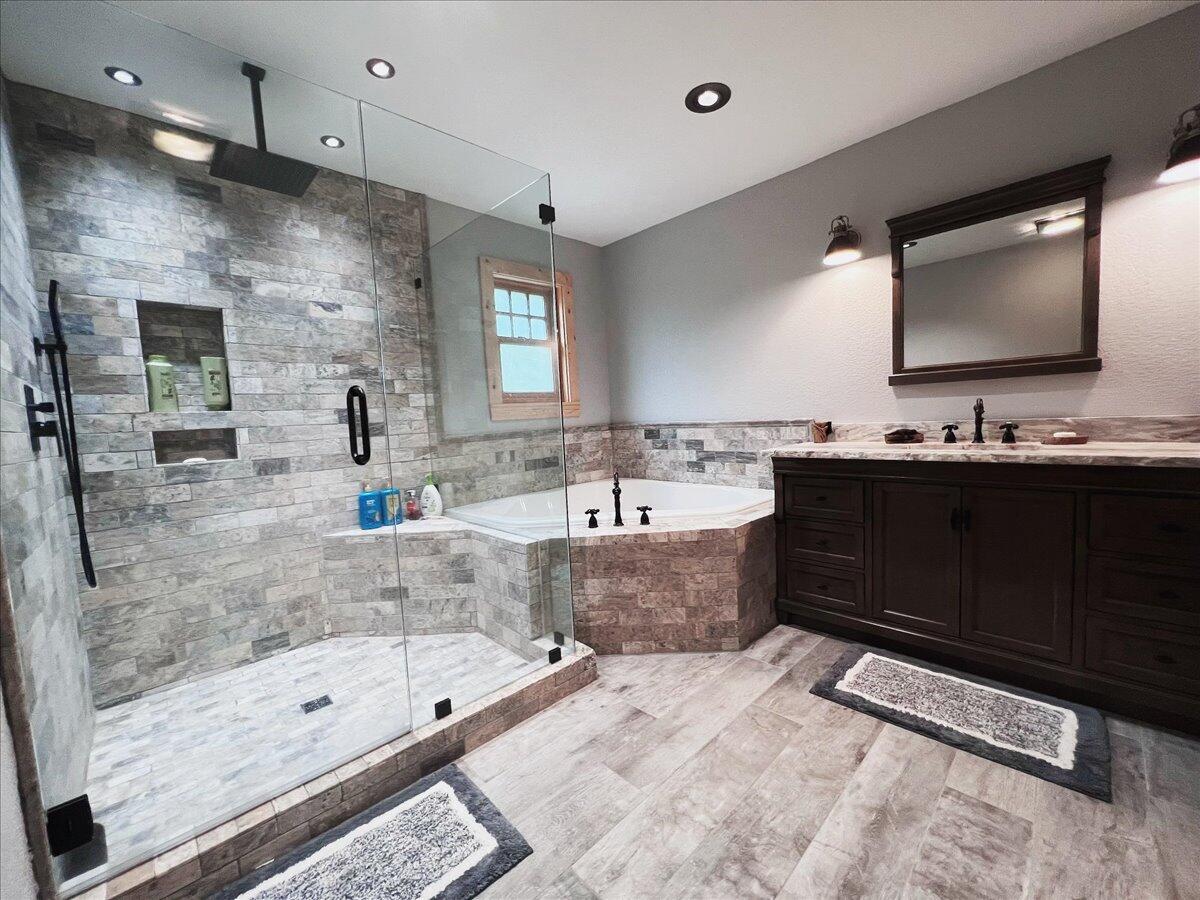 229 Madrid Road Cantonment, FL 32533 - Photo 40 of 84 a bathroom with a bathtub double vanity sink and a mirror
