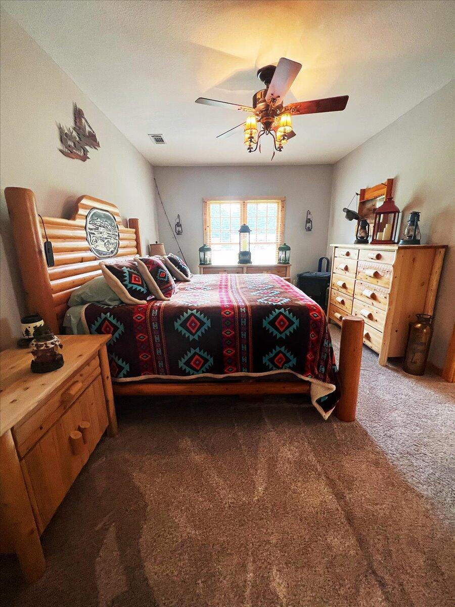 229 Madrid Road Cantonment, FL 32533 - Photo 43 of 84 a bedroom with a bed and a chandelier