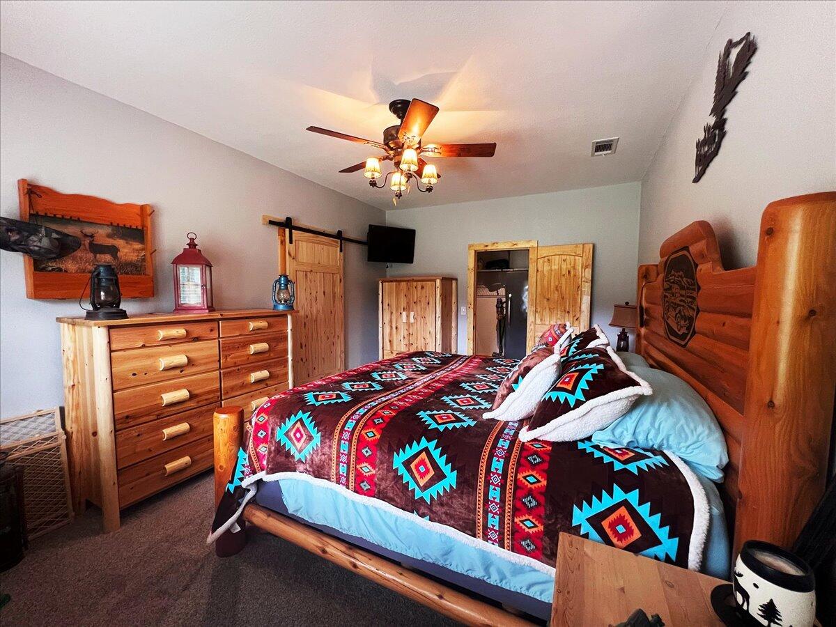 229 Madrid Road Cantonment, FL 32533 - Photo 51 of 84 a bedroom with a bed and a chandelier