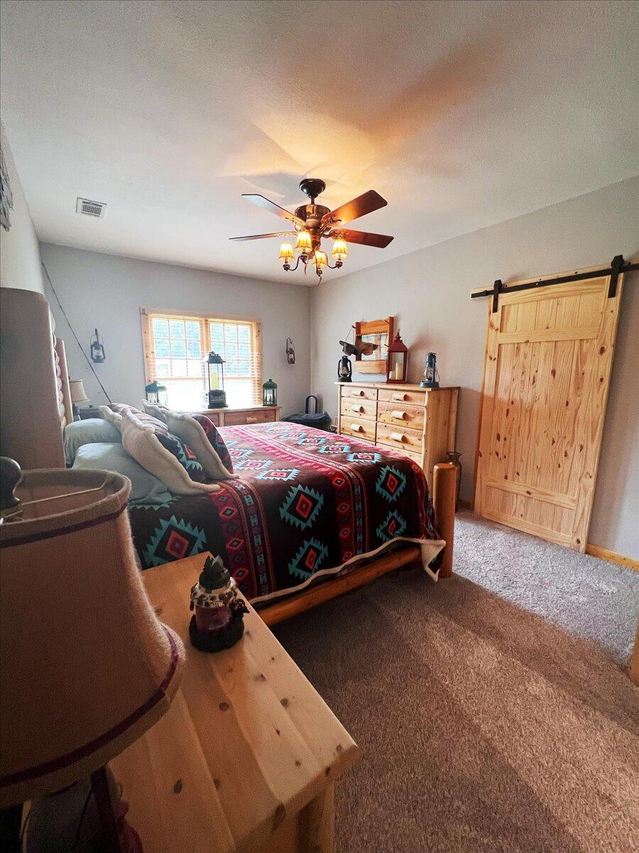 229 Madrid Road Cantonment, FL 32533 - Photo 53 of 84 a bedroom with a bed and wooden floor