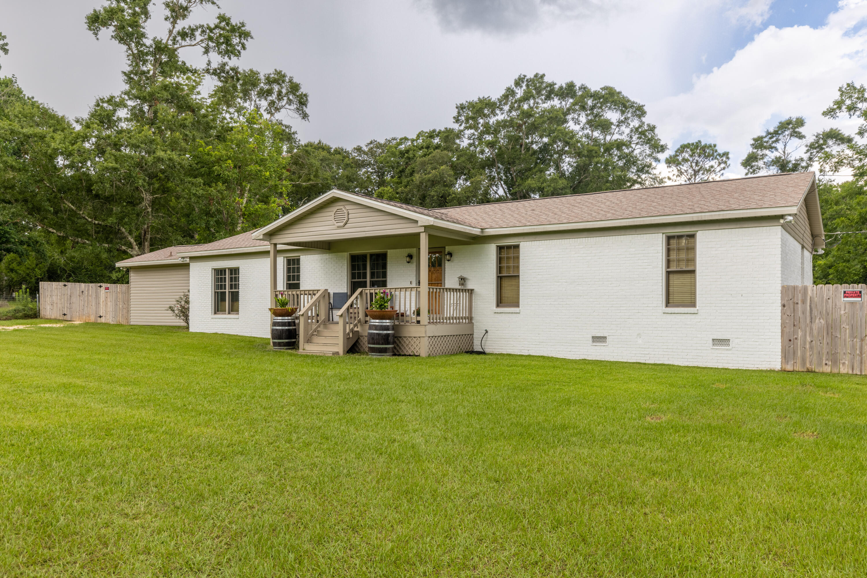 229 Madrid Road Cantonment, FL 32533 - Photo 57 of 84 a front view of a house with a garden