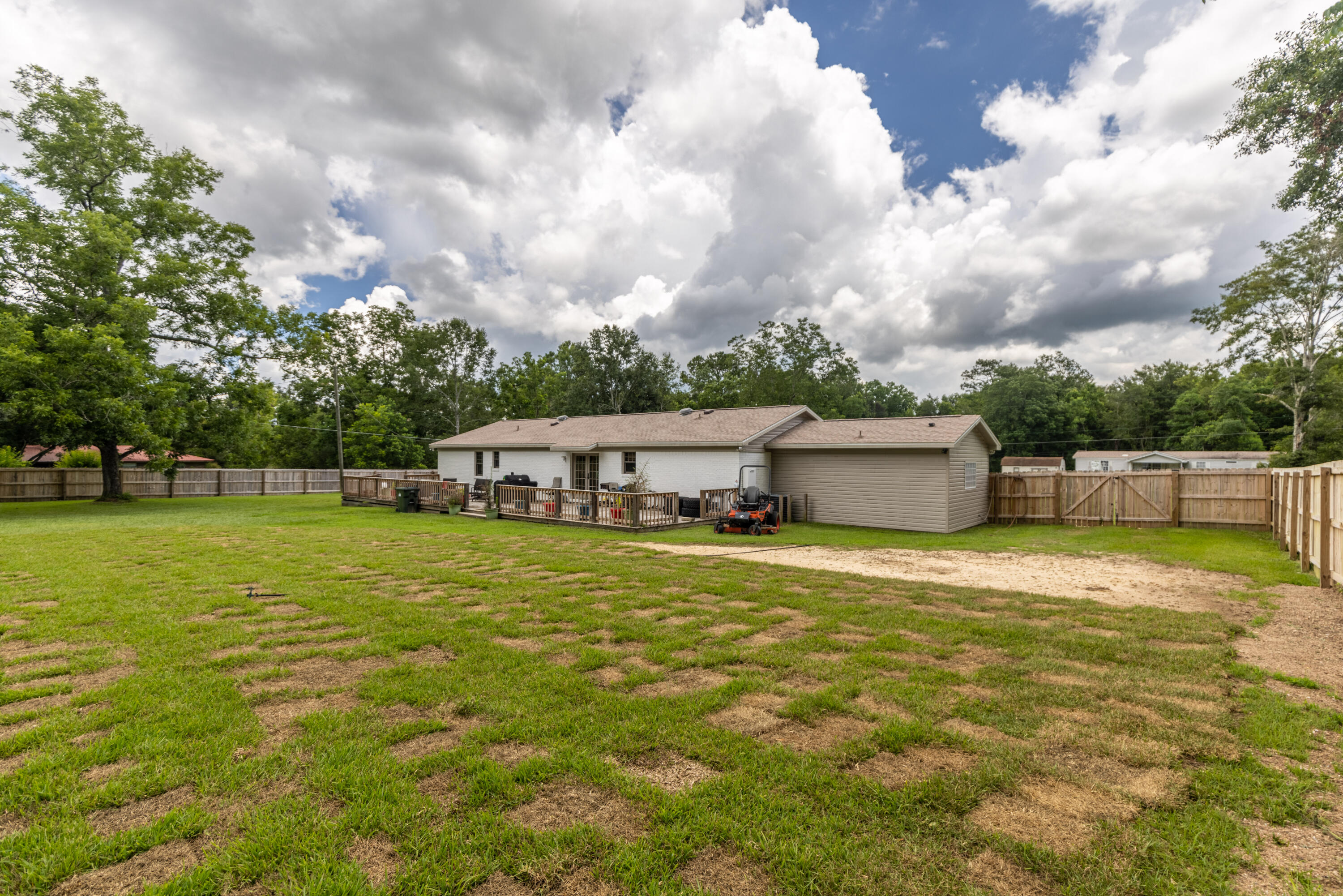 229 Madrid Road Cantonment, FL 32533 - Photo 64 of 84 a front view of a house with a garden and trees