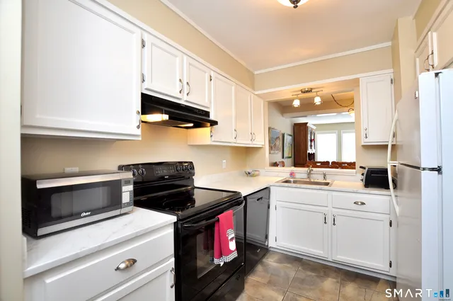 a kitchen with stainless steel appliances granite countertop a sink a stove and cabinets