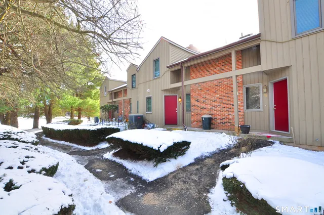 a view of a white house with a yard covered in snow