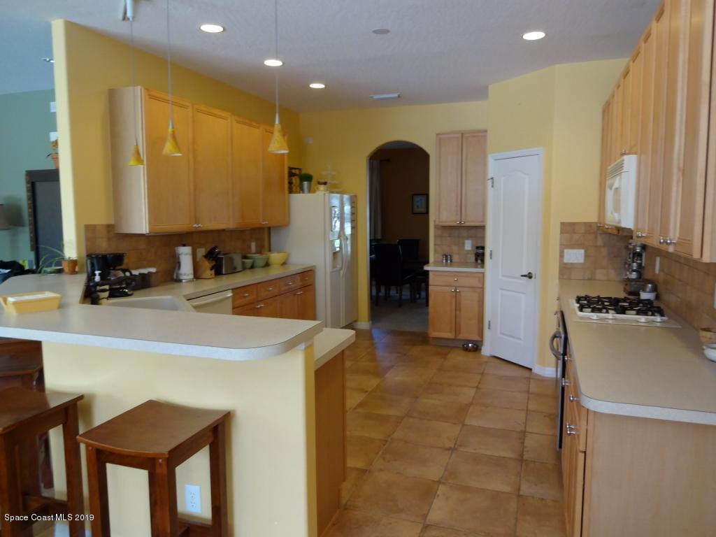 3763 Stream Drive Melbourne, FL 32940 - Photo 3 of 6 a view of a kitchen with kitchen island a sink stainless steel appliances and cabinets
