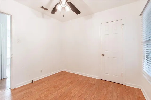 an empty room with wooden floor and closet