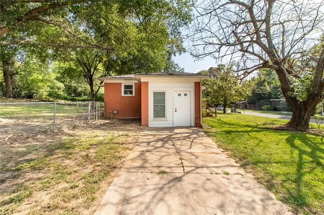 a view of a house with backyard and trees