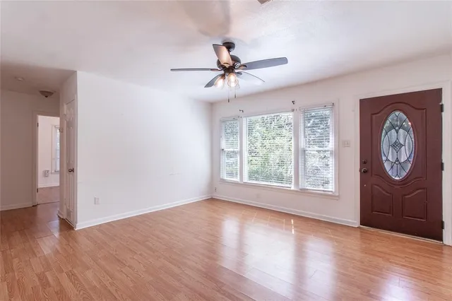 an empty room with a window and wooden floor
