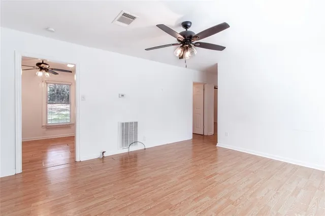 a view of a livingroom with wooden floor and a ceiling fan