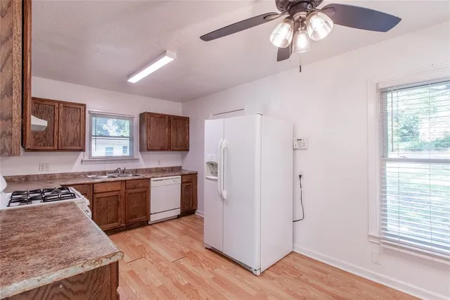a kitchen with stainless steel appliances granite countertop hardwood floor sink stove and refrigerator