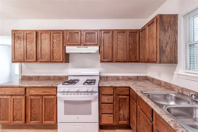 a kitchen with stainless steel appliances granite countertop a sink stove and cabinets
