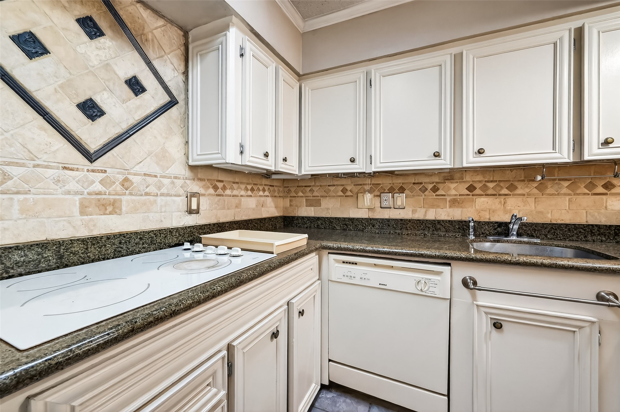 909 Silber Road, Unit 16C Houston, TX 77024 - Photo 13 of 32 a kitchen with granite countertop white cabinets sink and dishwasher