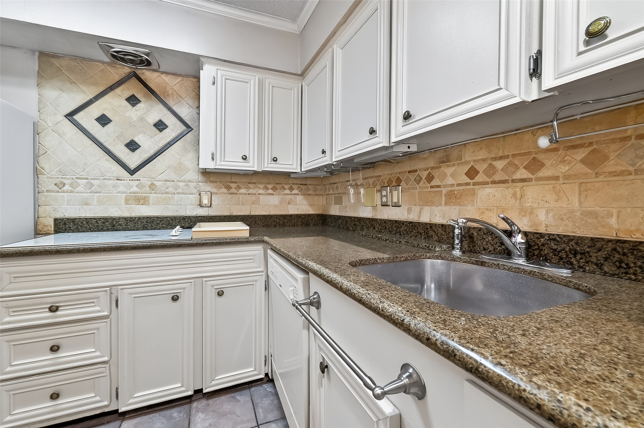 909 Silber Road, Unit 16C Houston, TX 77024 - Photo 16 of 32 a kitchen with granite countertop white cabinets and sink