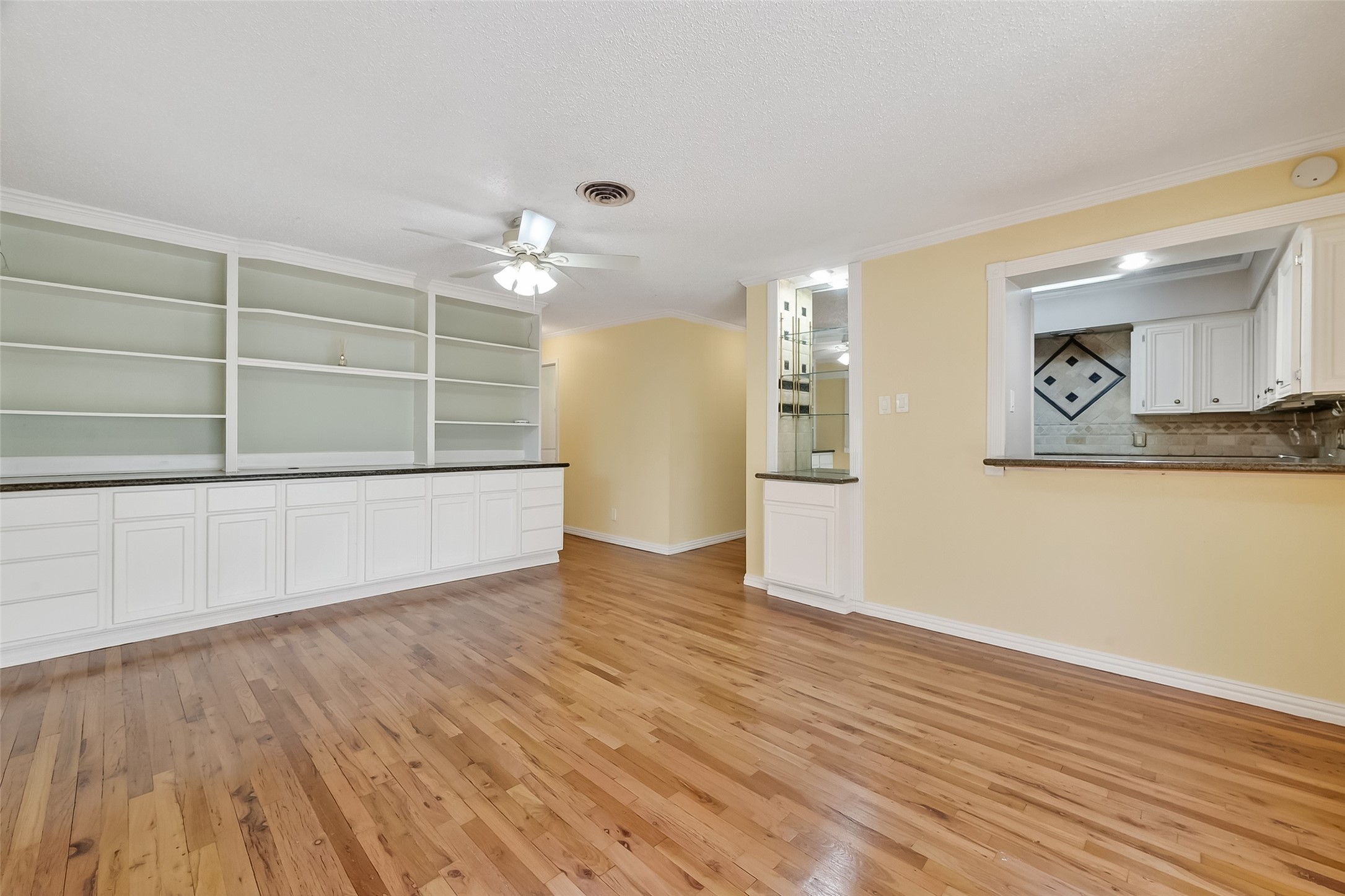 909 Silber Road, Unit 16C Houston, TX 77024 - Photo 8 of 32 a view of a kitchen with wooden floor and a ceiling fan