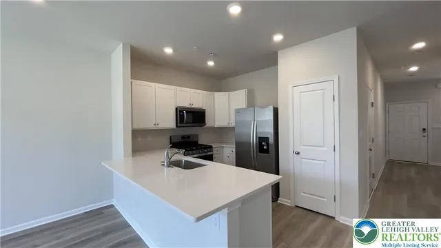 a kitchen with kitchen island a sink stainless steel appliances and cabinets
