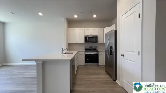 a kitchen with kitchen island wooden cabinets and stainless steel appliances