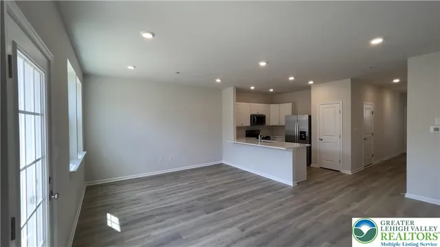 a kitchen with stainless steel appliances granite countertop a stove a sink and a refrigerator with wooden floor