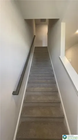 a view of a hallway with wooden floor and a flat screen tv
