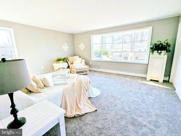 a bedroom with a bed table flowerpot and window