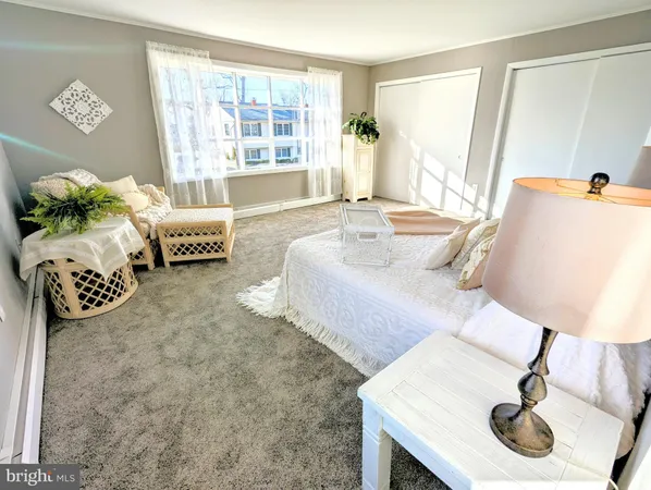 a spacious bedroom with a bed chair and window