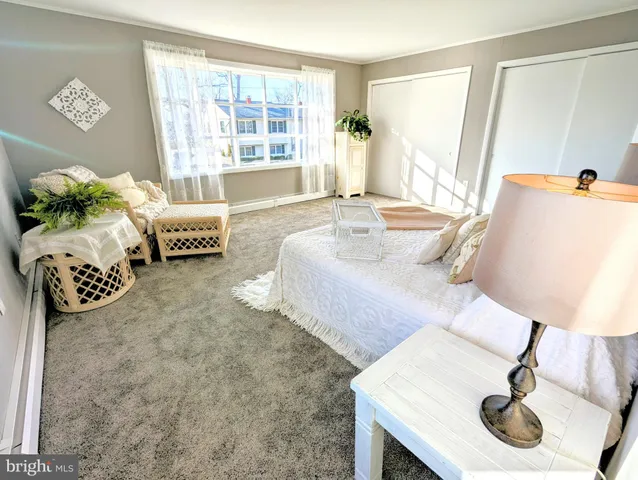 a spacious bedroom with a bed chair and window