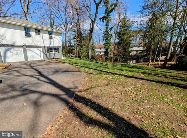 a view of a house with a big yard and large trees
