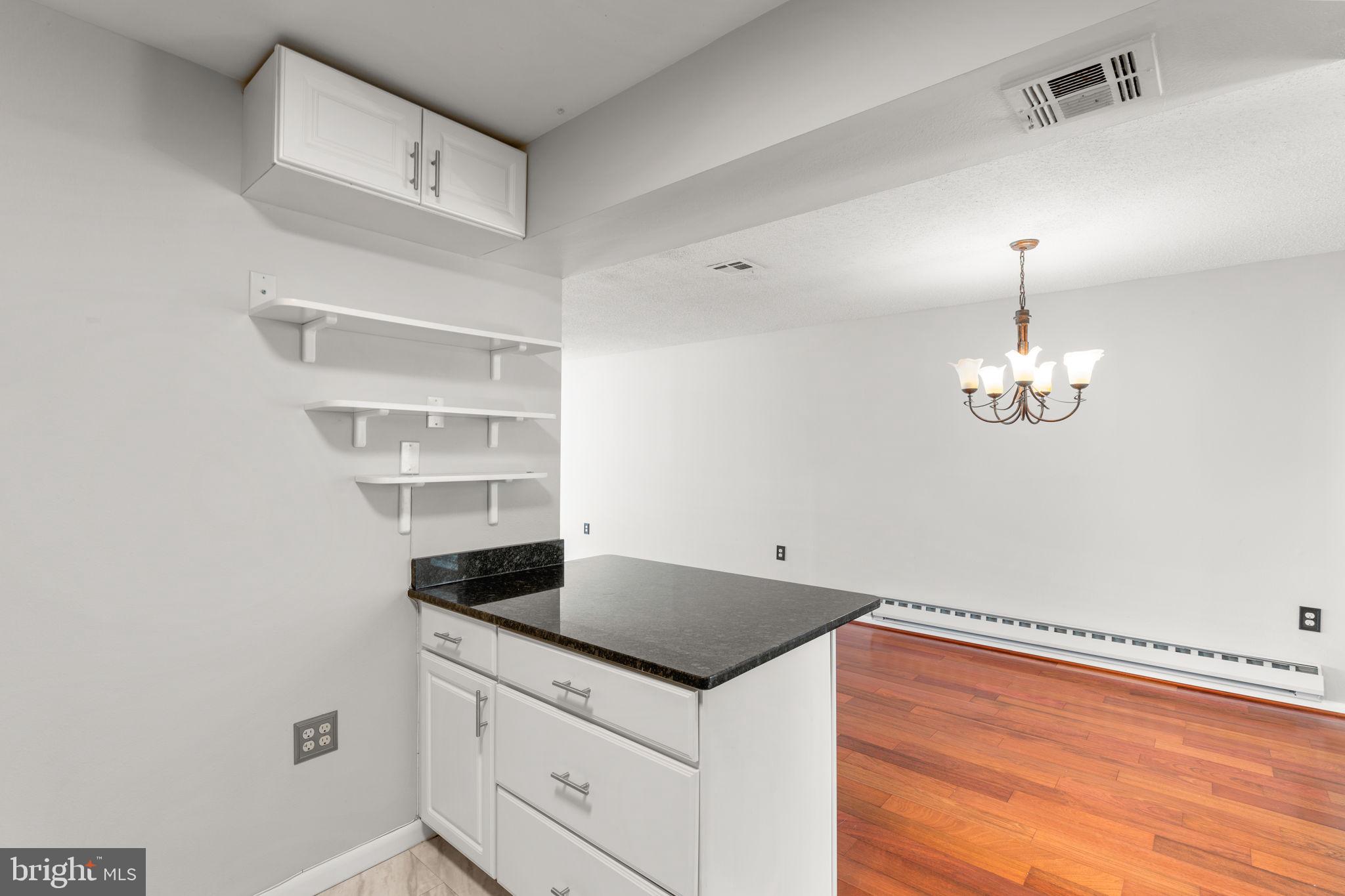 3415 Island Creek Court, Unit 131A Silver Spring, MD 20906 - Photo 10 of 32 a kitchen with a stove and a chandelier