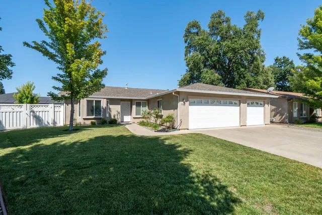 a front view of a house with yard and green space