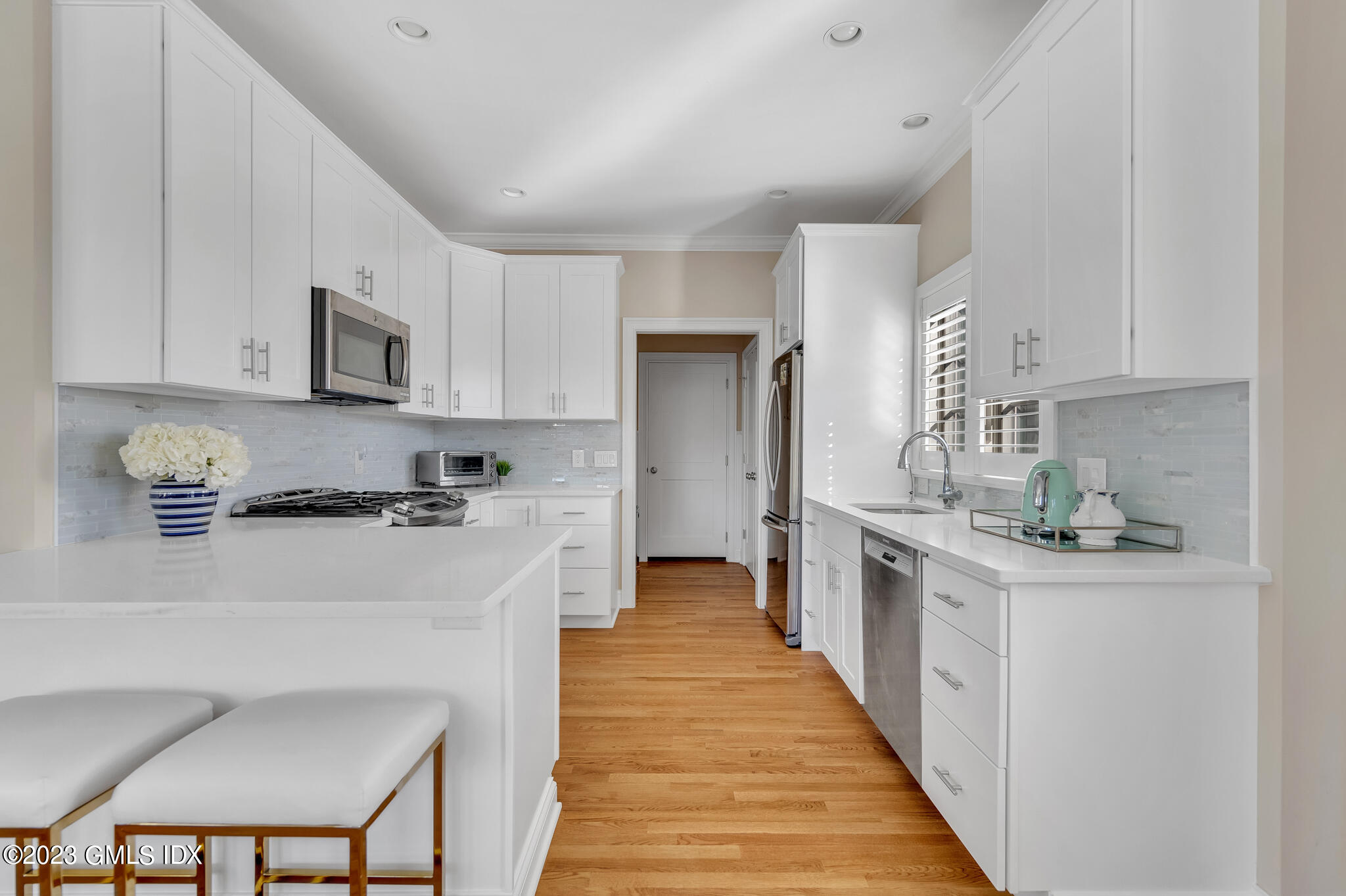 72 Havemeyer Place, Unit B Greenwich, CT 06830 - Photo 5 of 19 a kitchen with stainless steel appliances a stove top oven a sink a refrigerator white cabinets and wooden floor