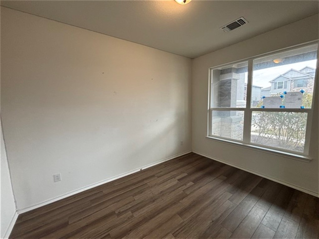 252 Benmyrtle Trail Georgetown, TX 78626 - Photo 7 of 17 a view of an empty room with wooden floor and a window