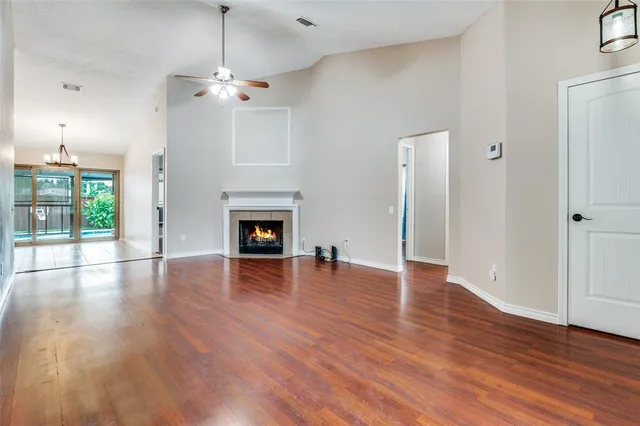 a view of a livingroom with wooden floor a fireplace and window