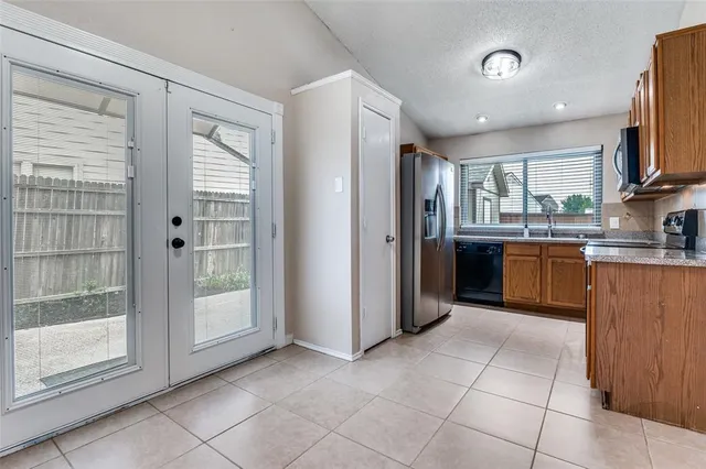 a kitchen with stainless steel appliances granite countertop a refrigerator and a sink
