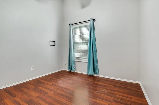 a view of a big room with wooden floor and windows