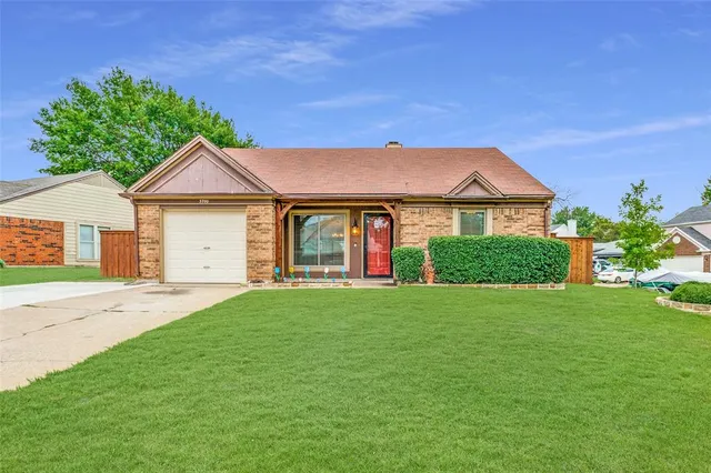 a front view of a house with a garden and yard