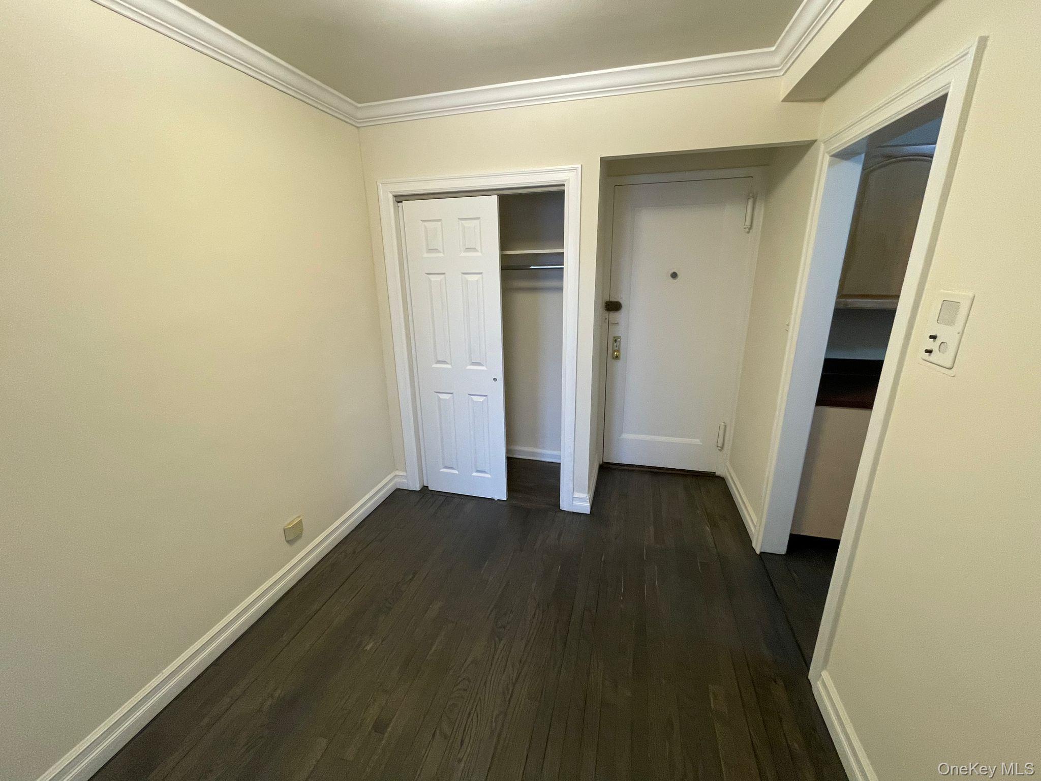 100-11 67th Road, Unit 4 Queens, NY 11375 - Photo 15 of 33 Unfurnished bedroom featuring dark wood-type flooring, ornamental molding, and a closet