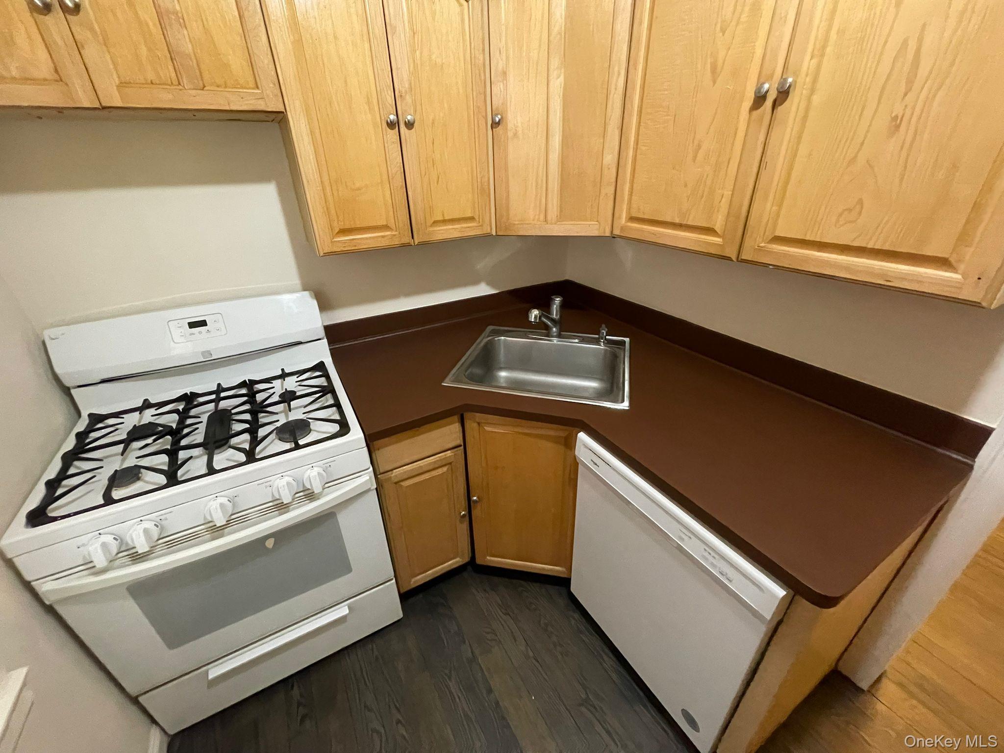 100-11 67th Road, Unit 4 Queens, NY 11375 - Photo 17 of 33 Kitchen featuring white appliances, dark countertops, and dark wood-type flooring