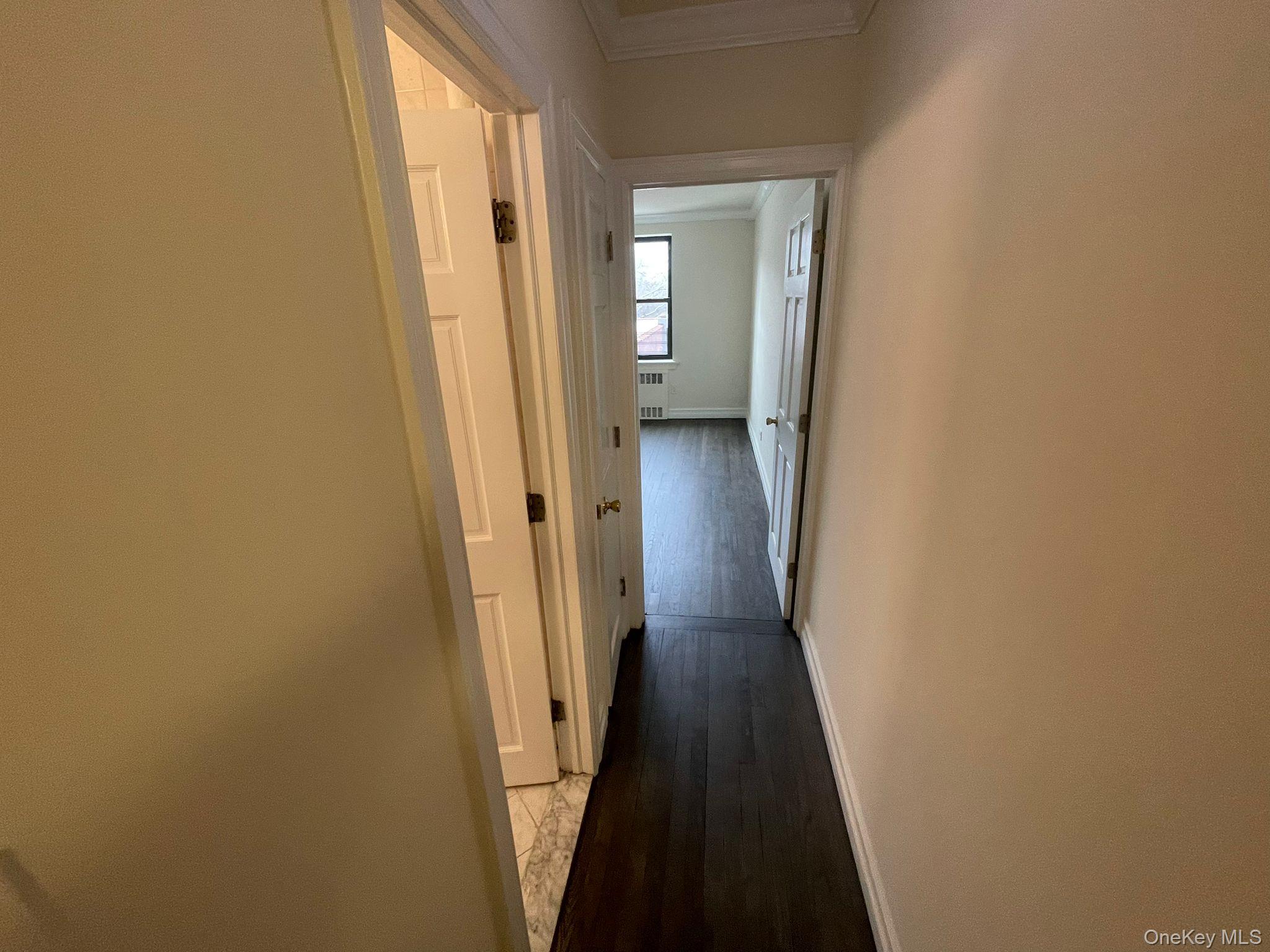 100-11 67th Road, Unit 4 Queens, NY 11375 - Photo 22 of 33 Hall featuring crown molding, dark wood-style flooring, and radiator heating unit