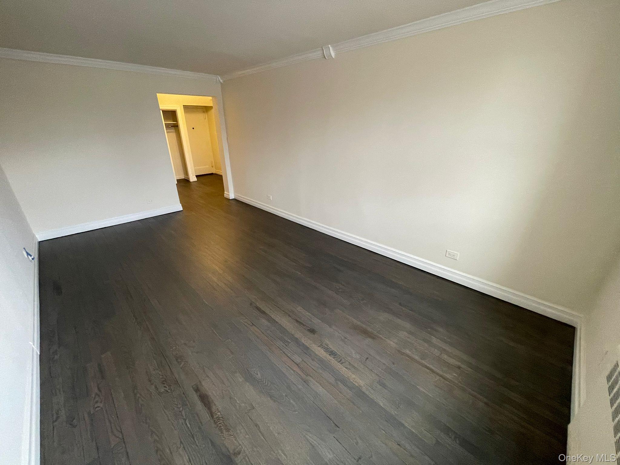 100-11 67th Road, Unit 4 Queens, NY 11375 - Photo 25 of 33 Spare room featuring crown molding and dark wood-style floors