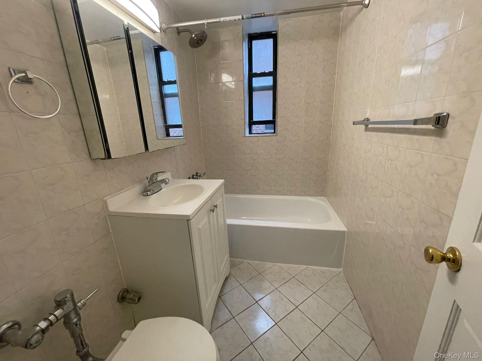 100-11 67th Road, Unit 4 Queens, NY 11375 - Photo 27 of 33 Full bathroom with tile walls, vanity, light tile patterned floors, and shower / washtub combination