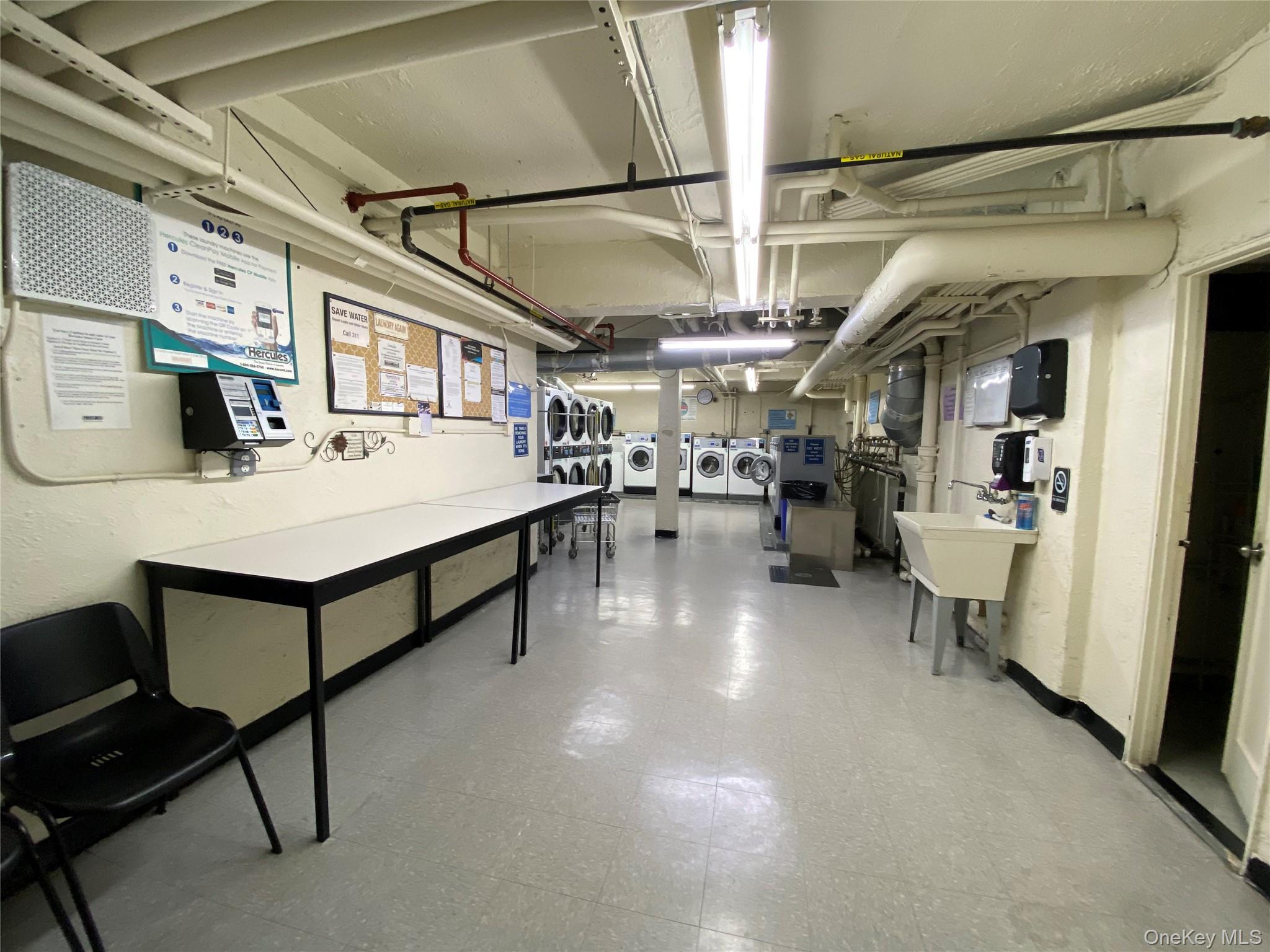 100-11 67th Road, Unit 4 Queens, NY 11375 - Photo 31 of 33 Unfinished below grade area with light floors, washing machine and dryer, and a textured wall