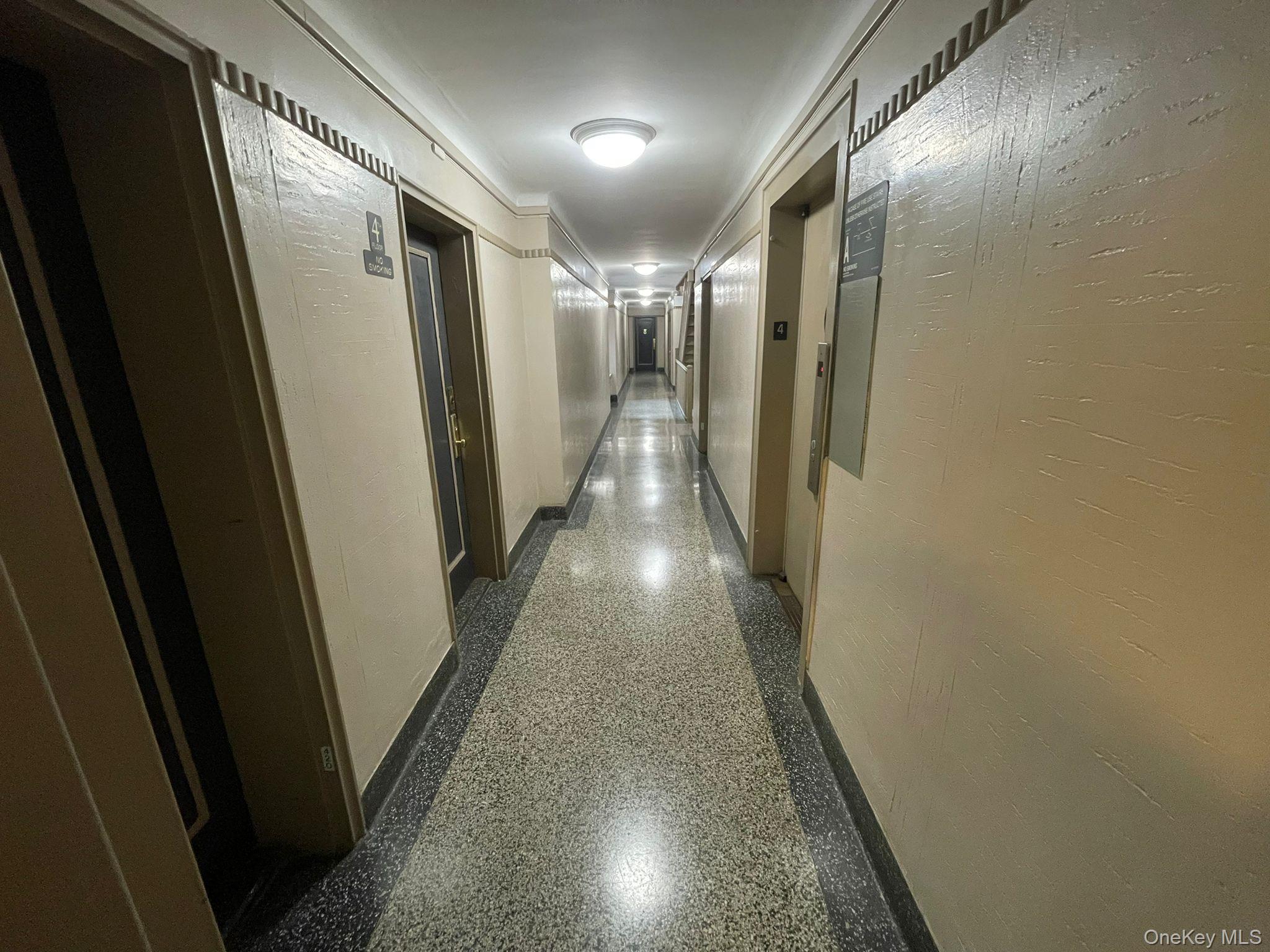 100-11 67th Road, Unit 4 Queens, NY 11375 - Photo 10 of 33 Hallway with speckled floor and elevator