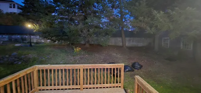 a view of backyard with a deck and garden