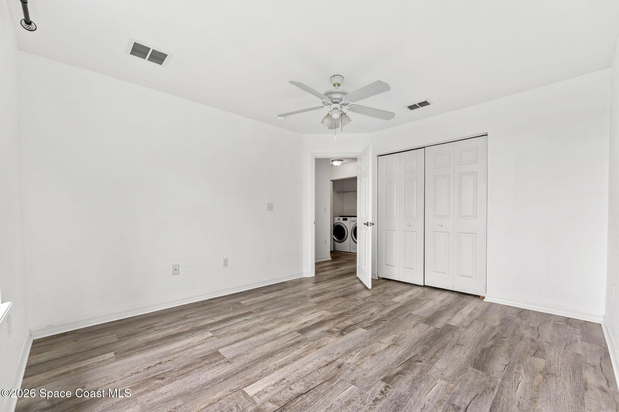 110 Turpial Way, Unit 106 Melbourne, FL 32901 - Photo 28 of 50 a view of empty room with wooden floor and ceiling fan