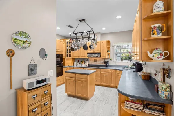 a kitchen with stainless steel appliances granite countertop a refrigerator a stove and a sink
