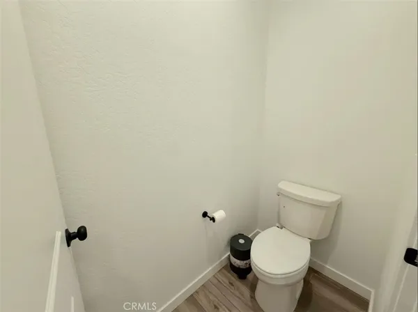 a white toilet sitting next to a white wall