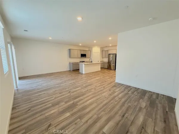 a view of a kitchen with a sink and dishwasher a refrigerator with wooden floor