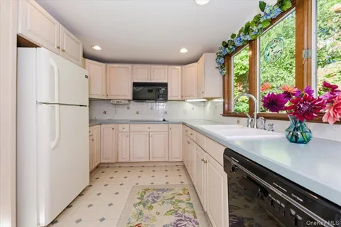 a kitchen with kitchen island white cabinets and white appliances