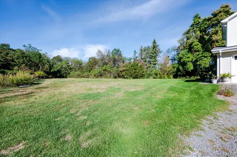 a view of a grassy field with trees in the background