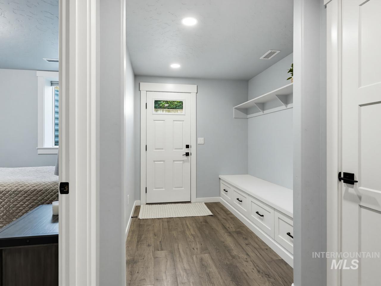 4950 West Columbia Road Nampa, ID 83687 - Photo 38 of 50 Entryway featuring wood-finish flooring, a white paneled entry door with an upper window, recessed lighting, and a built-in bench with storage drawers and an upper shelf