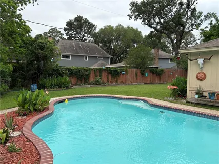 a view of swimming pool with a yard and plants